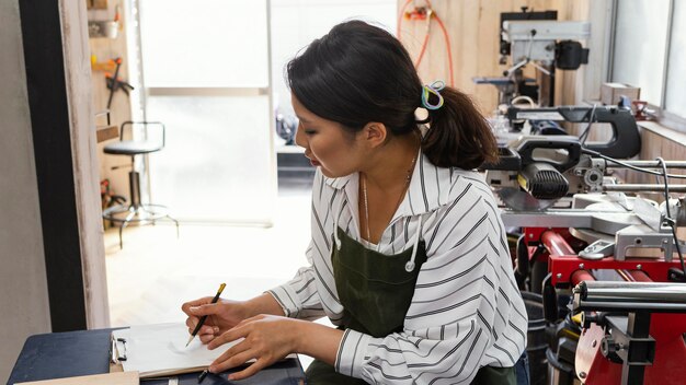 Medium shot woman holding pencil