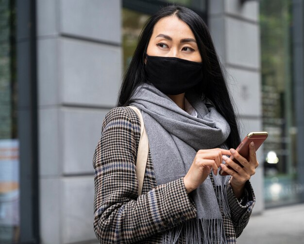 Medium shot woman holding phone