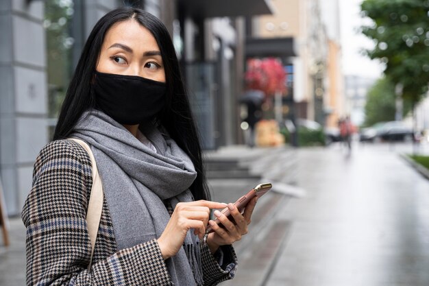 medium shot woman holding phone