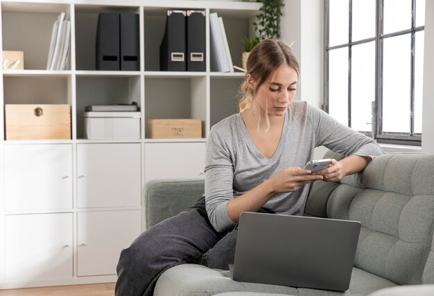 Medium shot woman holding phone