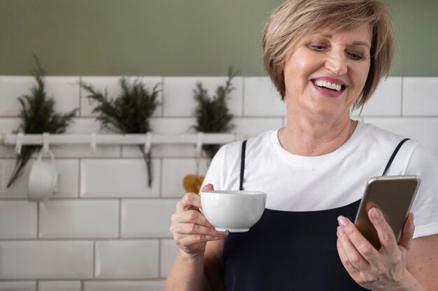 Medium shot woman holding phone