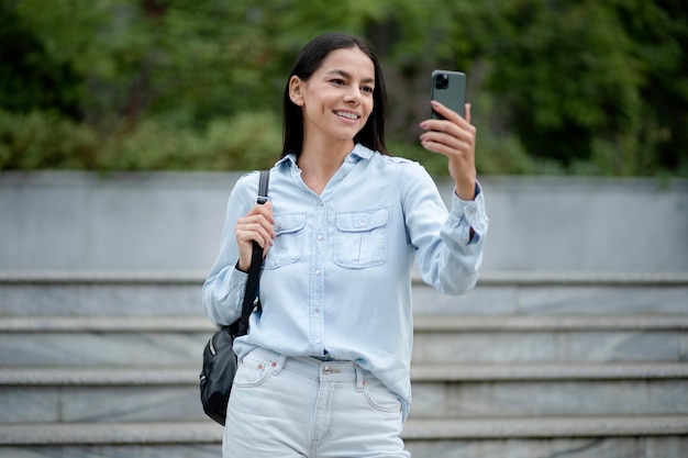 Medium shot woman holding phone