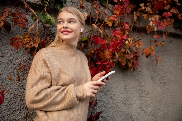 Medium shot woman holding phone