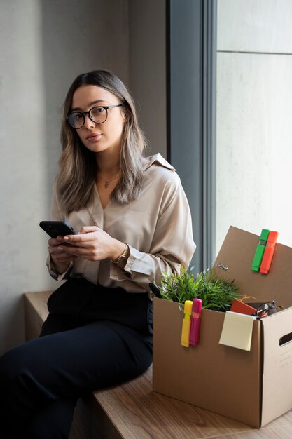 Medium shot woman holding phone