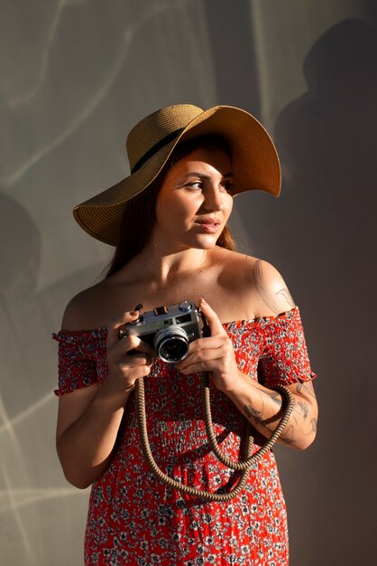 Medium shot woman holding photo camera