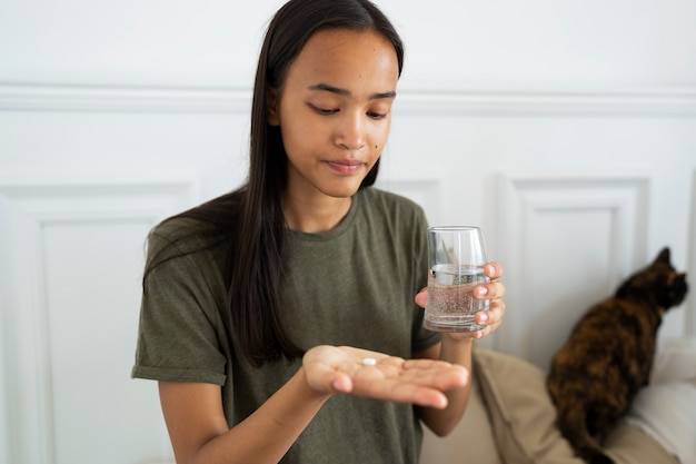 Free photo medium shot woman holding pill