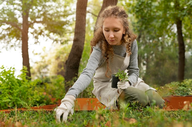 Free photo medium shot woman holding plant pot