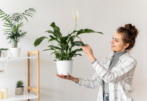 植物を保持しているミディアムショットの女性