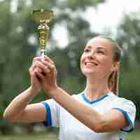 Free photo medium shot woman holding prize