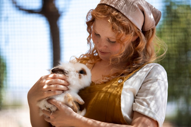 Medium shot woman holding rabbit