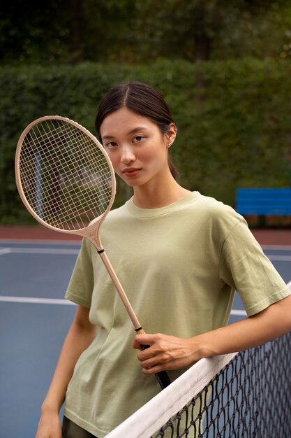 Medium shot woman holding racket