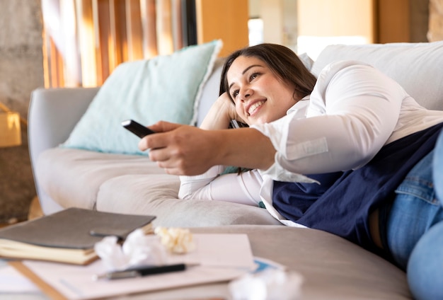 Foto gratuita telecomando della holding della donna del colpo medio