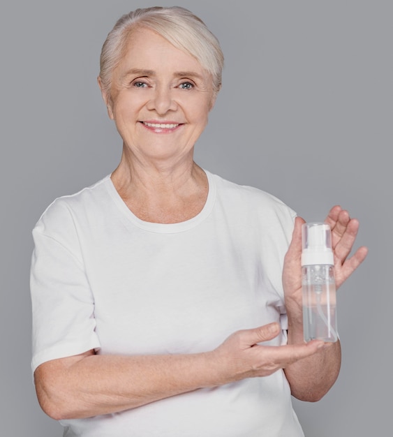 Medium shot woman holding serum bottle