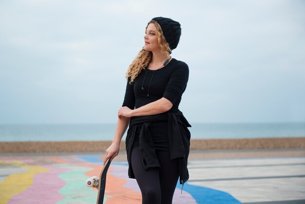 Medium shot woman holding skateboard
