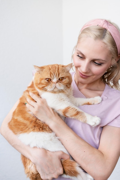 Medium shot woman holding sleepy cat