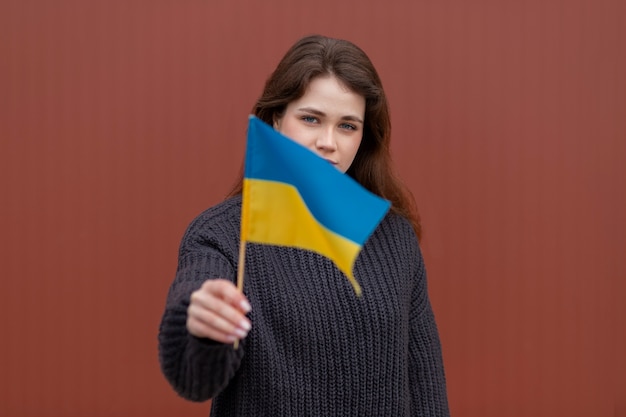 작은 우크라이나 국기를 들고 중간 샷 여자
