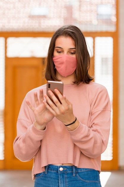 Medium shot woman holding smartphone