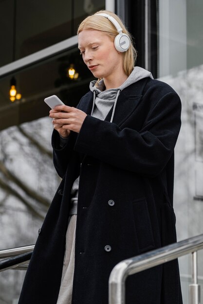 Medium shot woman holding smartphone