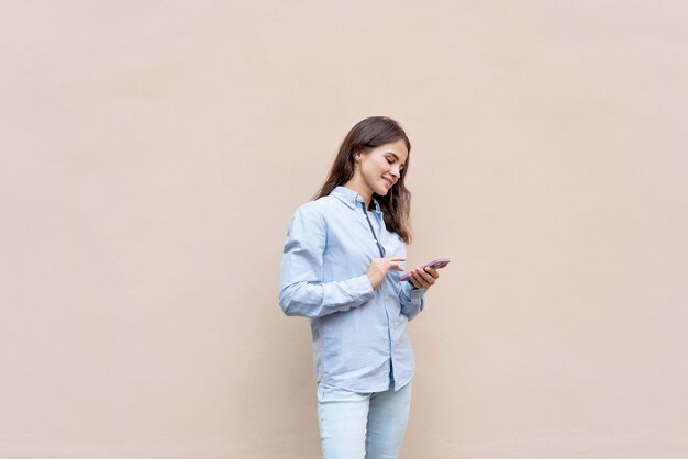 Medium shot woman holding smartphone