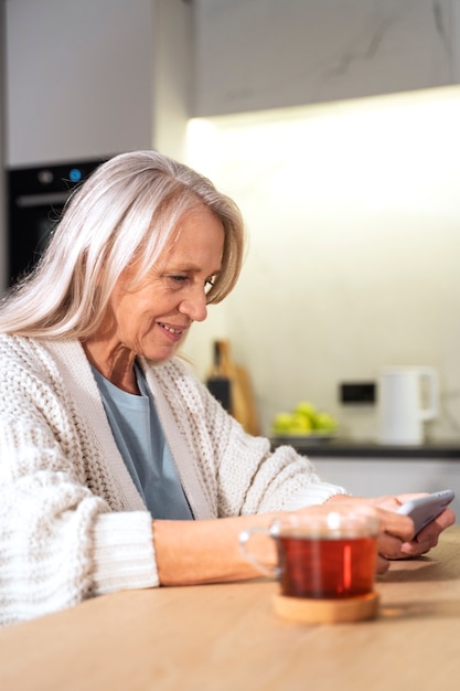 Foto gratuita donna con colpo medio che tiene smartphone