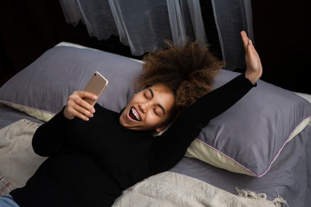 Medium shot woman holding smartphone