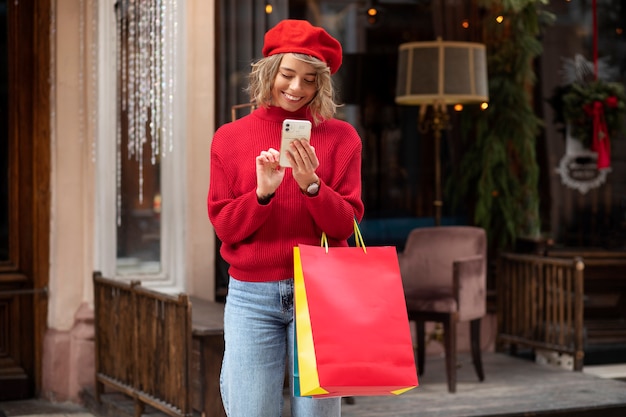 Medium shot woman holding smartphone