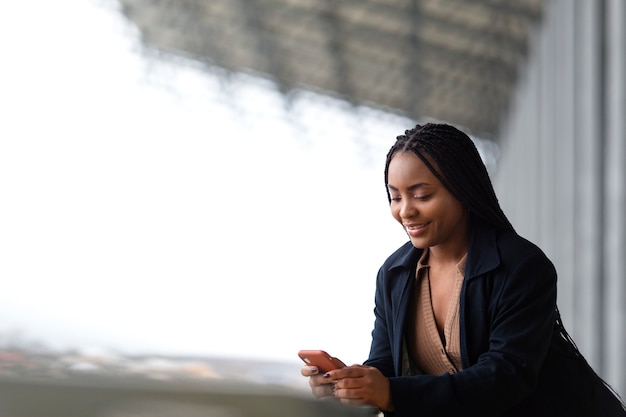 Medium shot woman holding smartphone