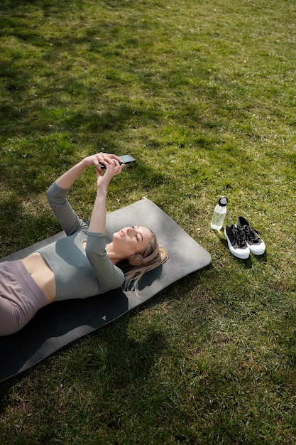 Smartphone della tenuta della donna del colpo medio