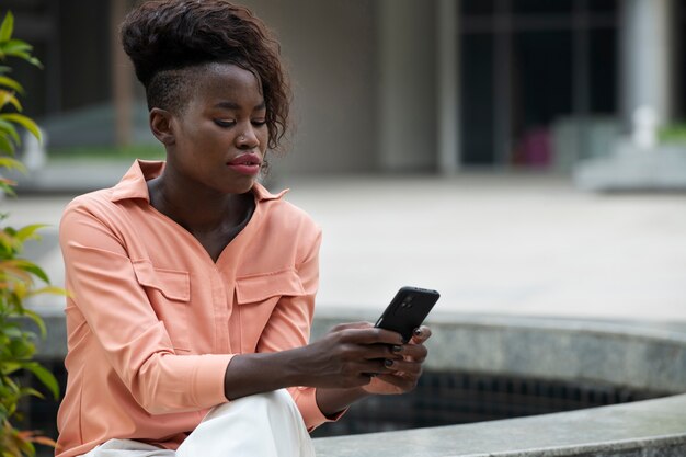 スマートフォンを保持しているミディアムショットの女性
