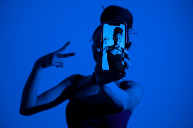 Medium shot woman holding smartphone