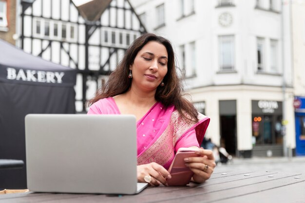 Medium shot woman holding smartphone