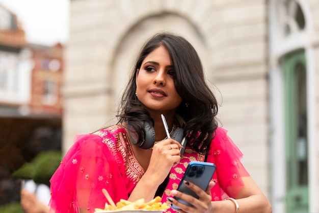 Medium shot woman holding smartphone