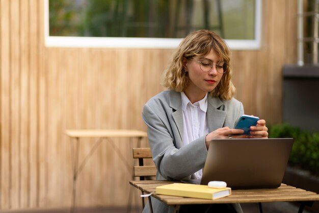 Medium shot woman holding smartphone