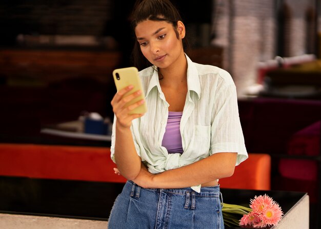 Medium shot woman holding smartphone