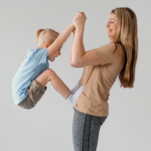 Free photo medium shot woman holding smiley kid