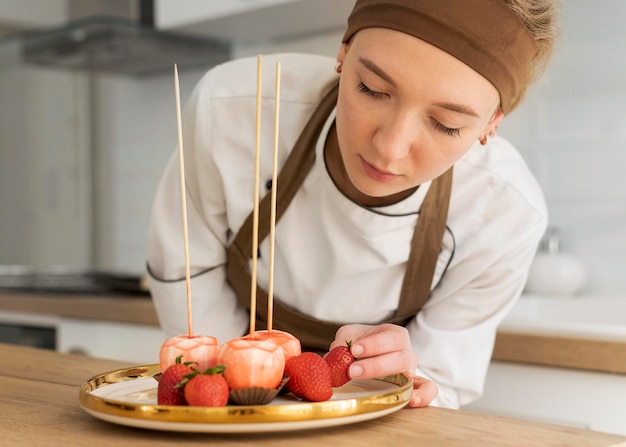 Medium shot woman holding strawberry