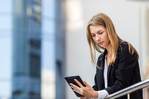 ミディアムショットの女性がタブレットを保持