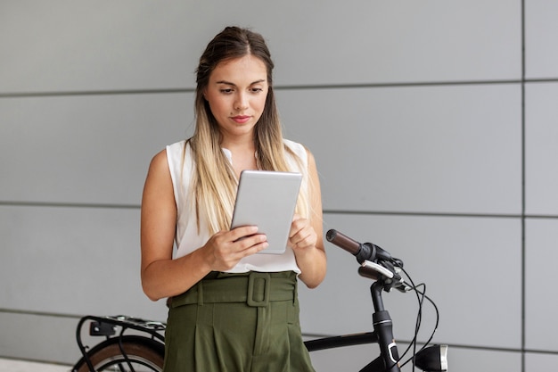 Medium shot woman holding tablet