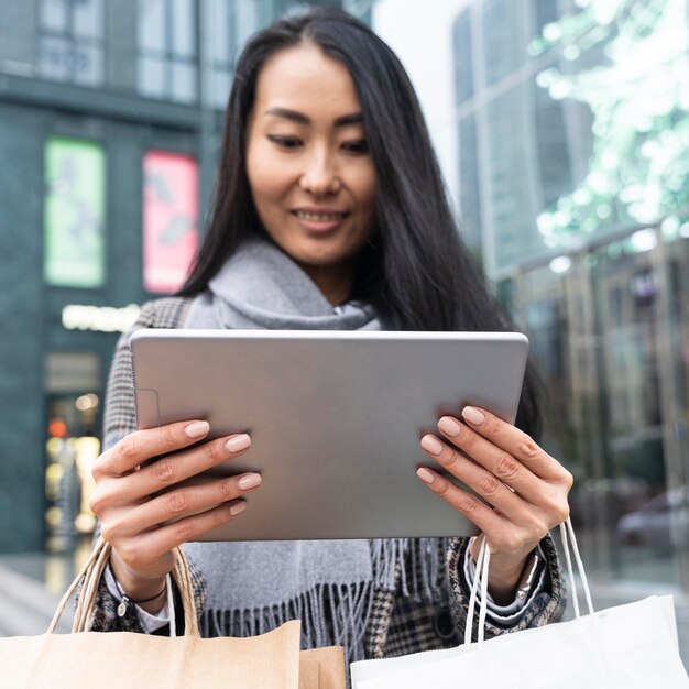 Medium shot woman holding tablet