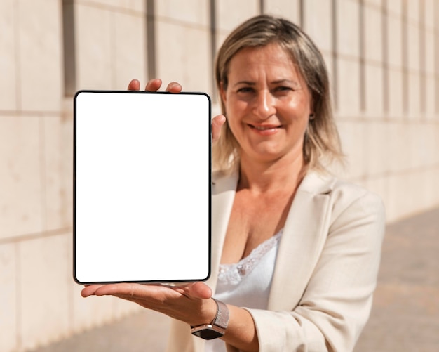 Medium shot woman holding tablet