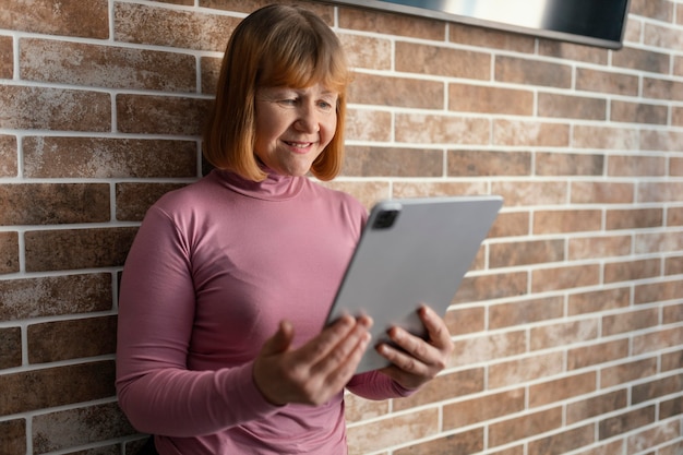 タブレットを保持しているミディアムショットの女性