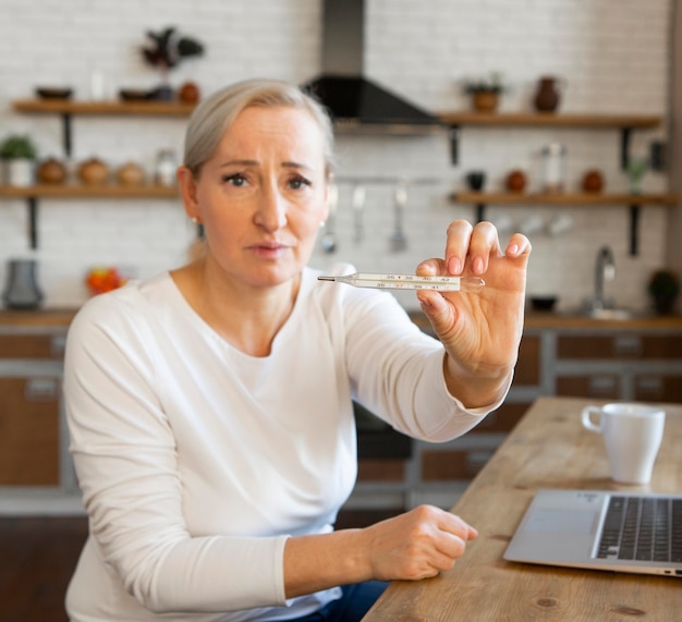 Medium shot woman holding thermometer