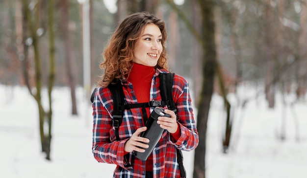 Medium shot woman holding thermos