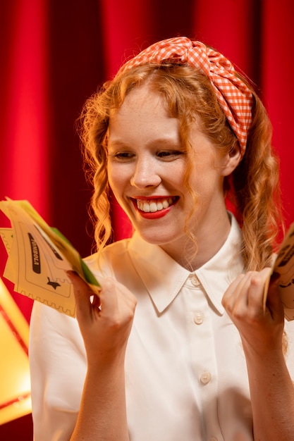 Medium shot woman holding tombola tickets