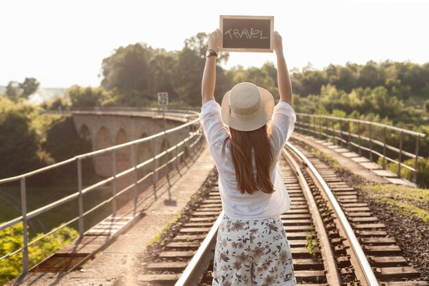 旅行ボードを保持しているミディアムショットの女性