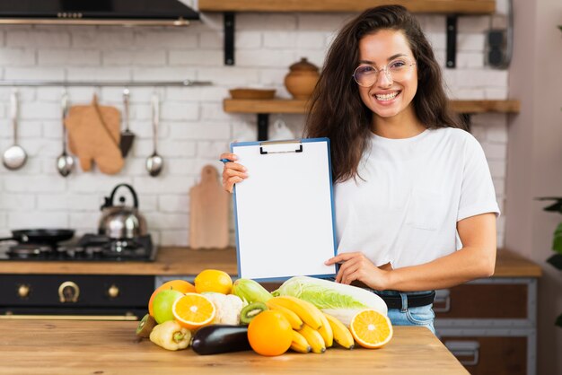 Medium shot woman holding up clipboard