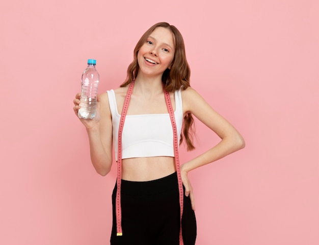 Medium shot woman holding water bottle