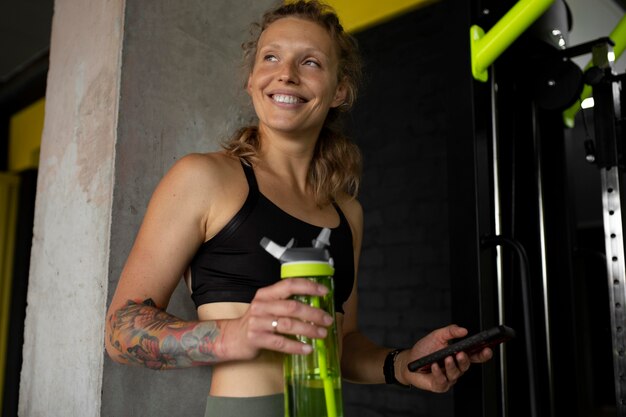 Medium shot woman holding water bottle