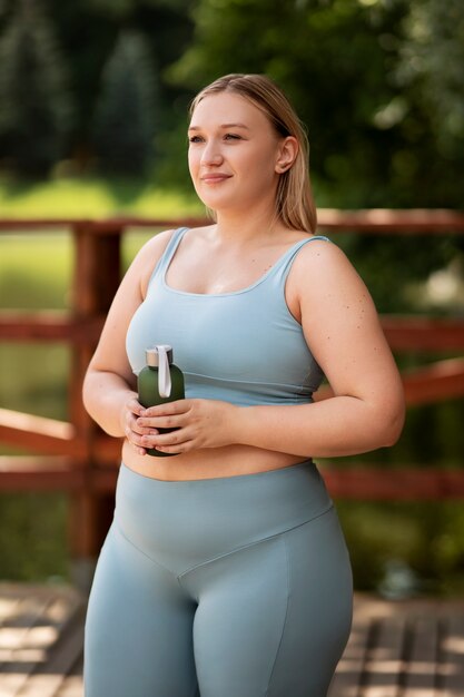 Medium shot woman holding water bottle