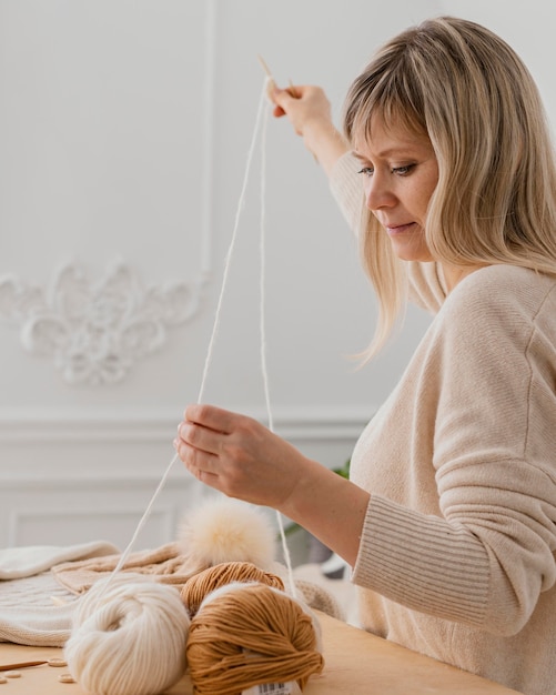 Free photo medium shot woman holding white thread